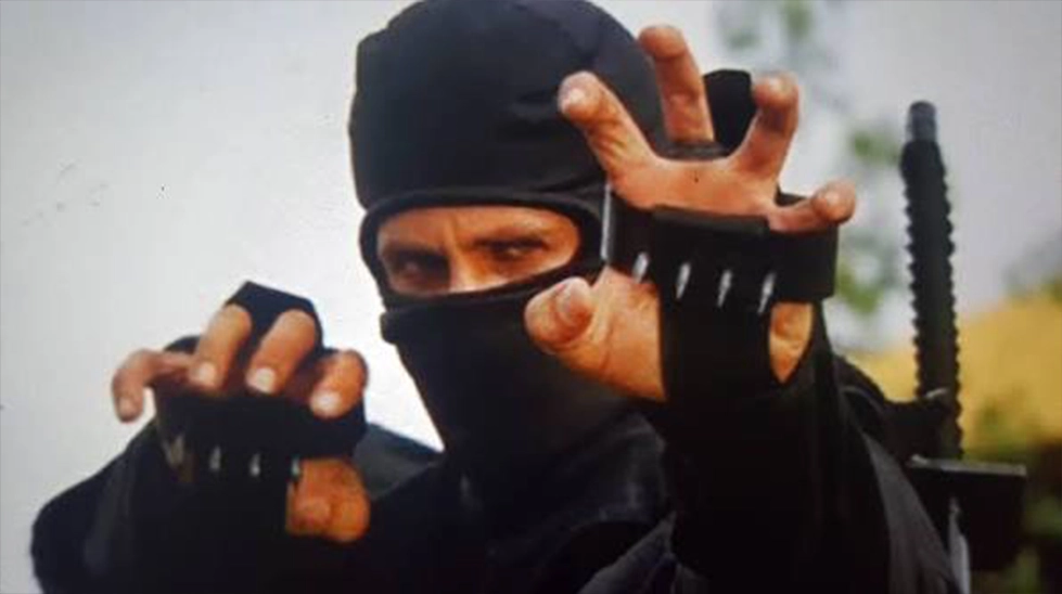 Black ninja preparing to attack with shuko hand claws in the movie American Ninja.