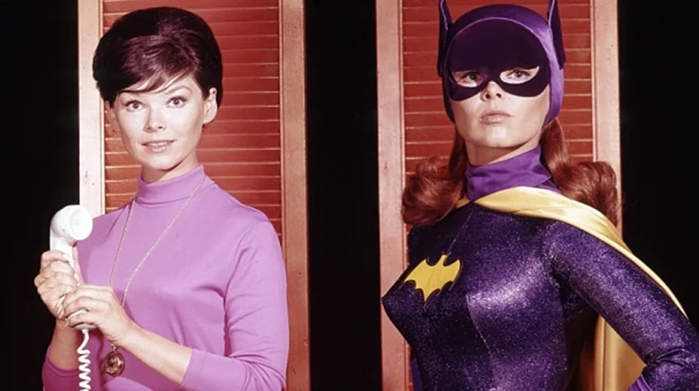 Yvonne Craig, klasik Batman dizisindeki kütüphaneci Barbara Gordon sivil hali ve ikonik mor Batgirl kostümüyle yan yana.