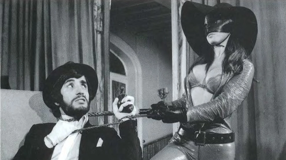 Figen Han'ın canlandırdığı maskeli kadının elinde kamçıyla bir adamı rehin aldığı, Kamçılı Kadın filminden ikonik bir sahne.